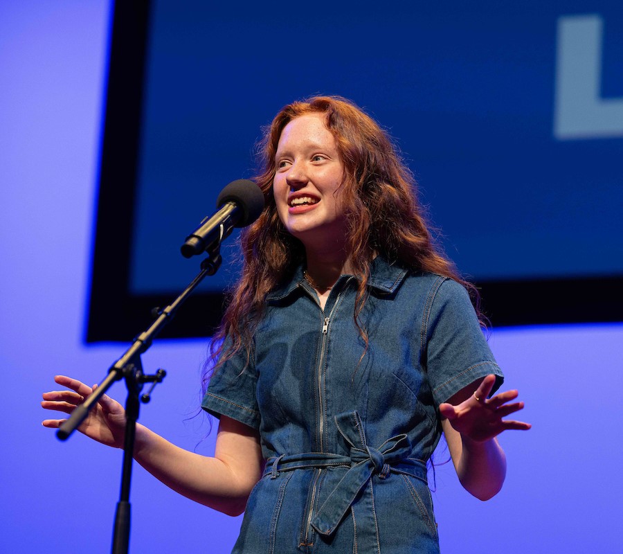 A student recites on stage.